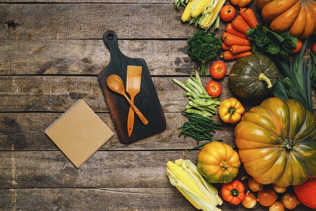 Tabla de cortar de madera con verduras de otoño en la vista superior de la mesa de madera