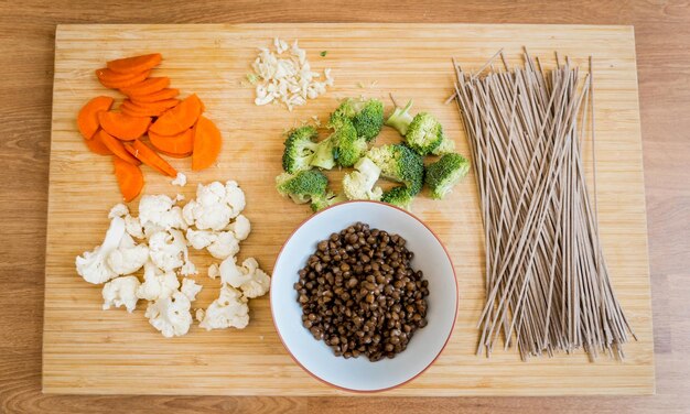 Tabla de cortar con pasta de trigo sarraceno japonés crudo y lentejas