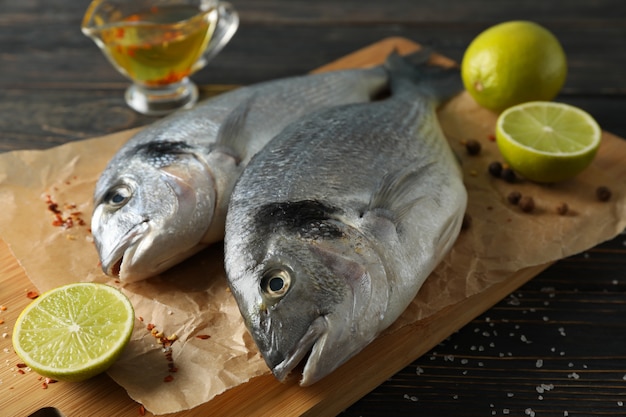 Tabla de cortar con peces Dorado, lima y especias en madera