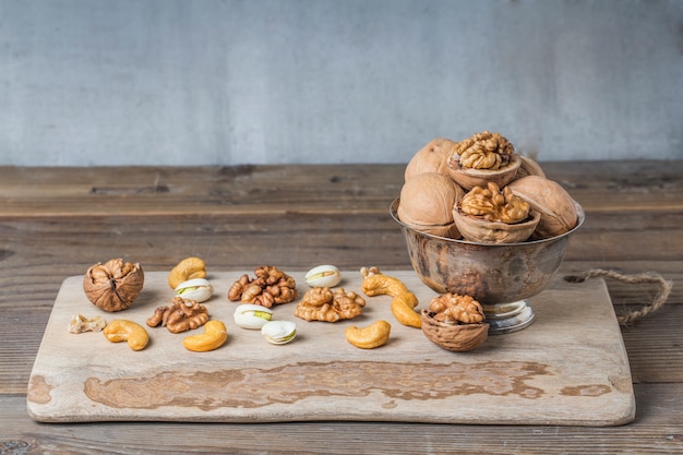 Foto tabla de cortar con un recipiente metálico y frutos secos