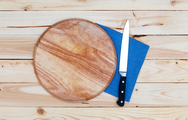 Foto tabla de cortar redonda con un cuchillo en una mesa de madera