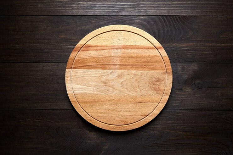 Tabla de cortar redonda sobre mesa de madera marrón