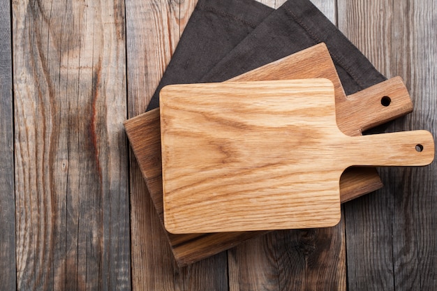 Tabla de cortar del roble sobre la toalla en la tabla de madera de la cocina.