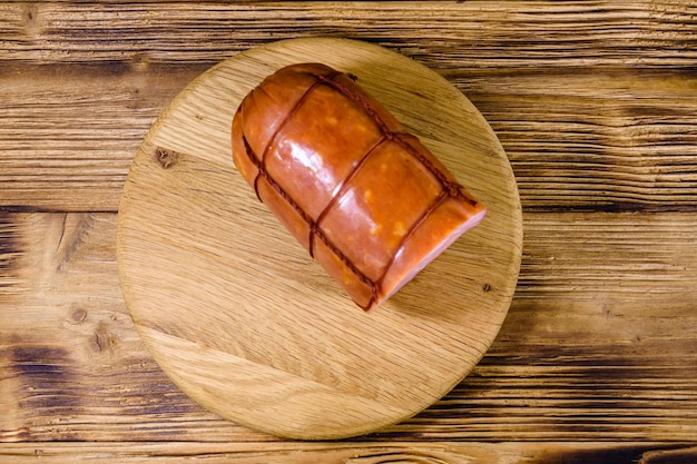 Tabla de cortar con salchicha en la mesa de madera Vista superior