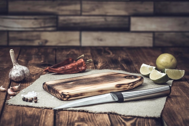 Tabla de cortar sobre una mesa de madera con especias Tabla de cortar hecha a mano Verduras frescas y tabla de cortar
