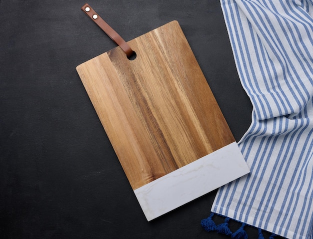 Tabla de corte de cocina de madera rectangular vacía en la vista superior de la mesa negra