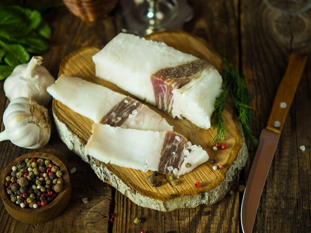 Tabla con grasa de cerdo en un fondo rústico Salo deliciosa manteca de cerdo salada con pimienta Lugar para copiar