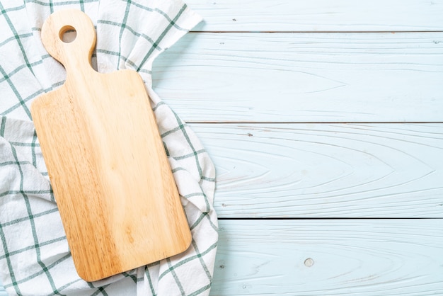 Tabla de madera de corte vacía con paño de cocina