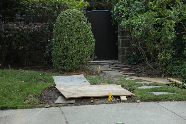 Una tabla de madera está tirada en el suelo frente a una casa.