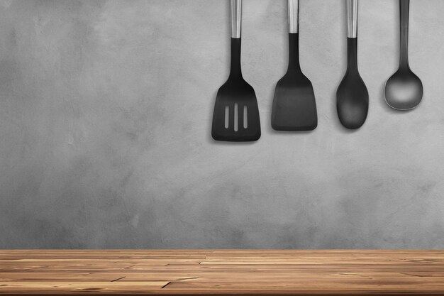 Foto tabla de madera vacía y equipo de cocina fondo de pared de cemento