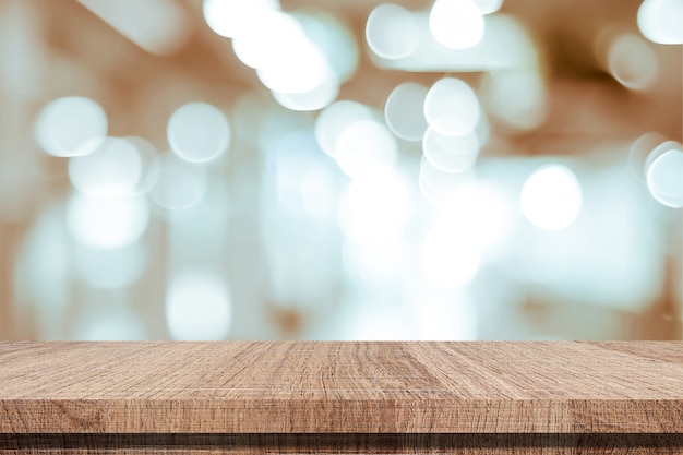 La tabla de madera vacía sobre fondo de la tienda de la falta de definición, producto y comida exhibe el fondo del montaje