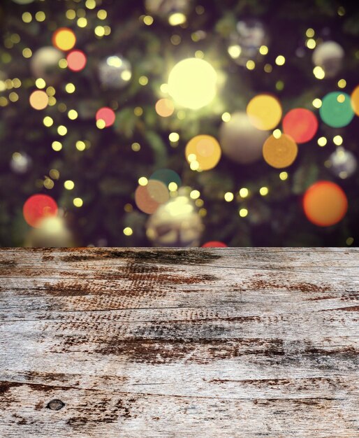 Tabla de madera vieja y vacía frente a la Navidad o feliz año nuevo tiempo de fondo árbol de Navidad con bolas de colores fondo de vacaciones montaje de exhibición de productos