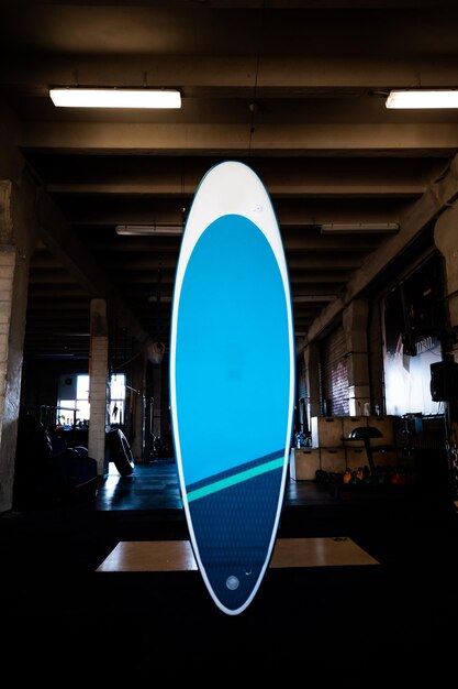 Tabla de paddle inflable azul SUP junto a la pared Equipo de surf y sup boarding de cerca