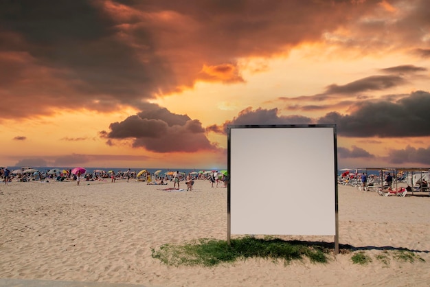 Foto tabla publicitaria en blanco en una playa llena de gente en verano