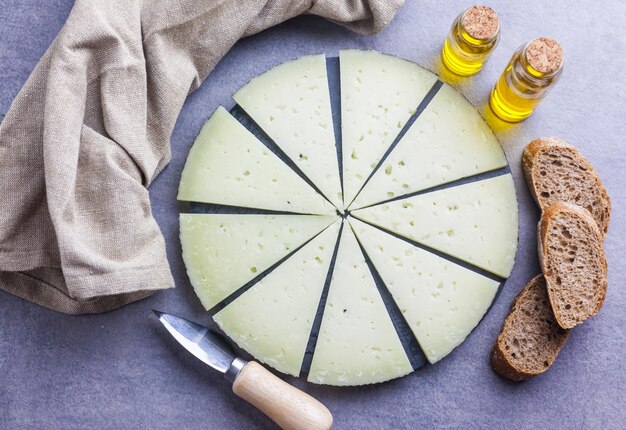 Foto tabla de queso manchego curado con pan y aceite de oliva