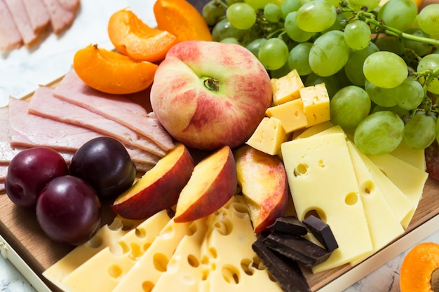 Tabla de quesos con frutas y carne.