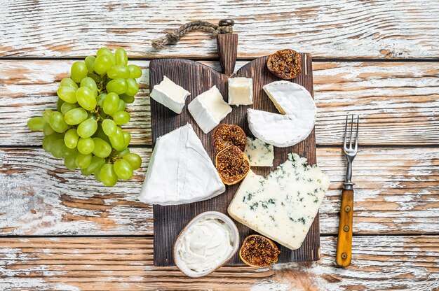 Tabla de quesos con queso brie, camembert, gorgonzola y crema de queso azul.