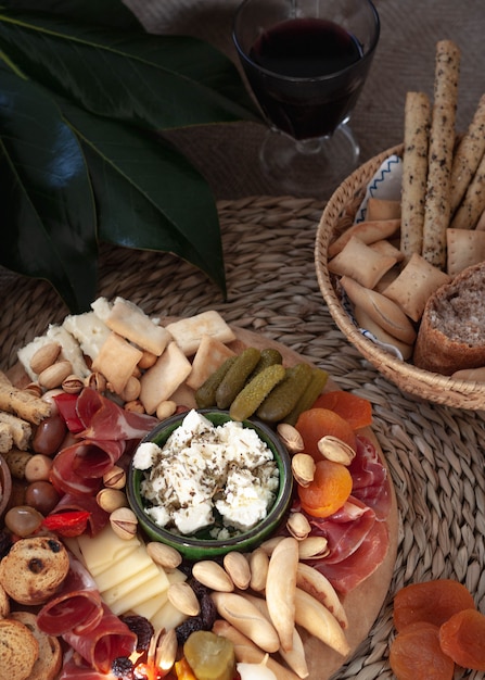 Tabla de quesos con selección de aperitivos, variedad de quesos, embutidos, galletas saladas, aceitunas. Comida colorida Vista superior.