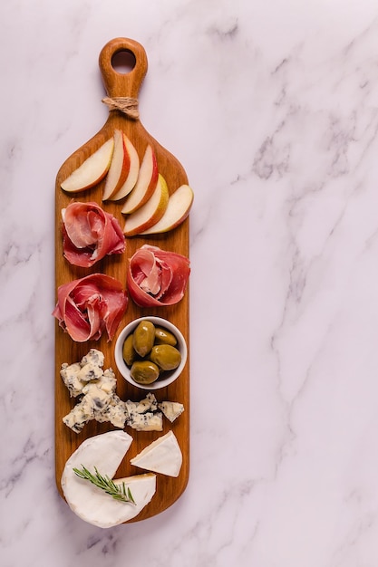 Tabla de servir con vista superior de bocadillos de carne y queso