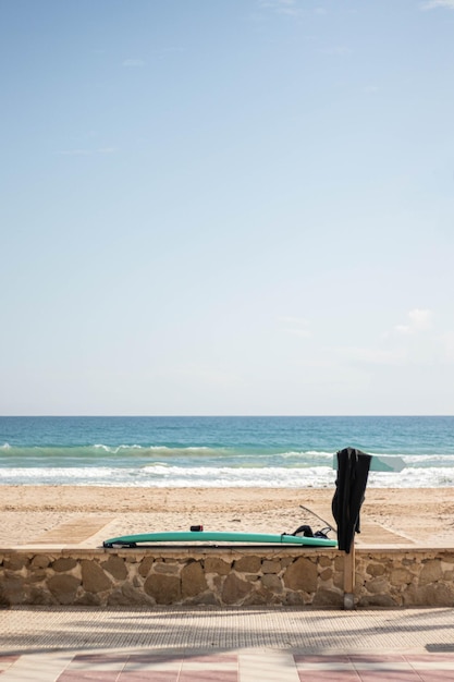 Tabla de surf apoyada contra una pared en una playa mediterránea