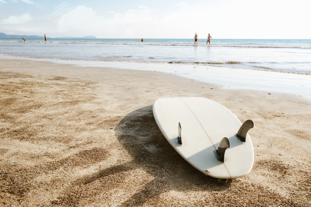 Tabla de surf dejada sobre la arena en la playa