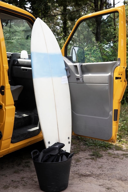 Tabla de surf junto a una furgoneta amarilla