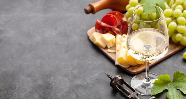 Tabla de uva y aperitivo de copa de vino blanco