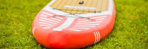 Tablas de surf tiradas en la hierba junto al lago del río o pancarta marina de formato largo