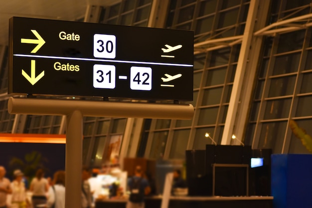Tablero de anuncios digital con señales de puerta de enlace del aeropuerto.