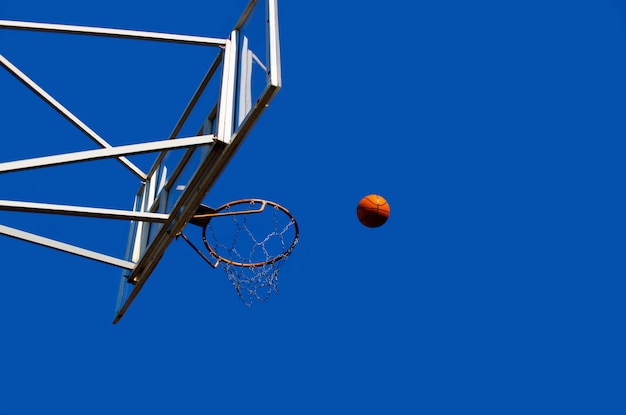 Tablero de baloncesto con un anillo en la calle en el patio de recreo con el fondo del cielo