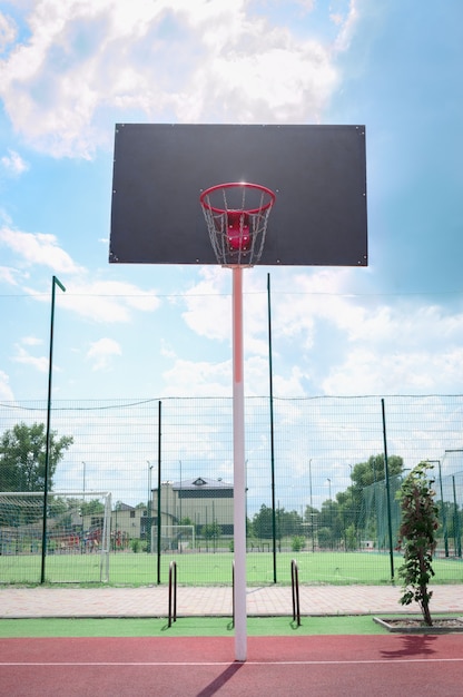 Tablero de baloncesto con una canasta hecha de cadenas de hierro en un día soleado. Vista vertical. Vista de ángulo bajo