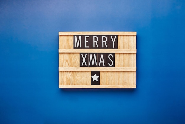 Foto tablero de cartas con texto feliz navidad sobre fondo azul tarjeta navideña concepto de saludos navideños flatlay