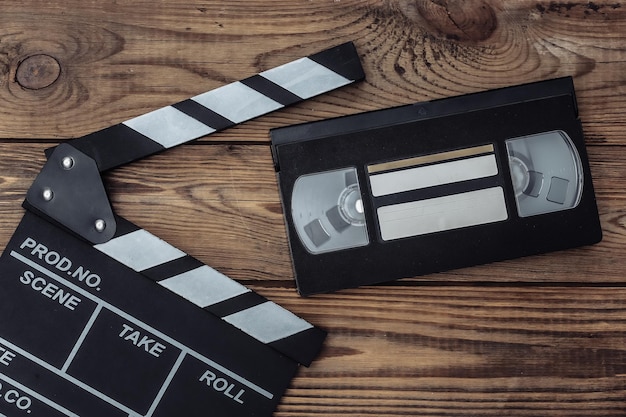 Tablero de chapaleta de película y casete de video sobre fondo de madera. Industria del cine, entretenimiento. Vista superior