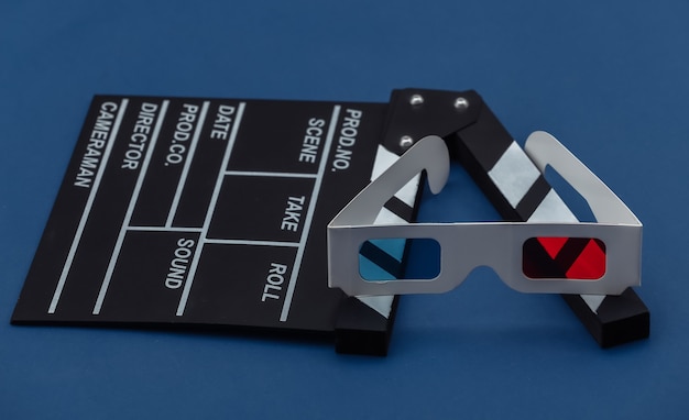 Foto tablero de chapaleta de película con gafas 3d sobre fondo azul clásico. cine, producción de películas, industria del entretenimiento. color 2020.
