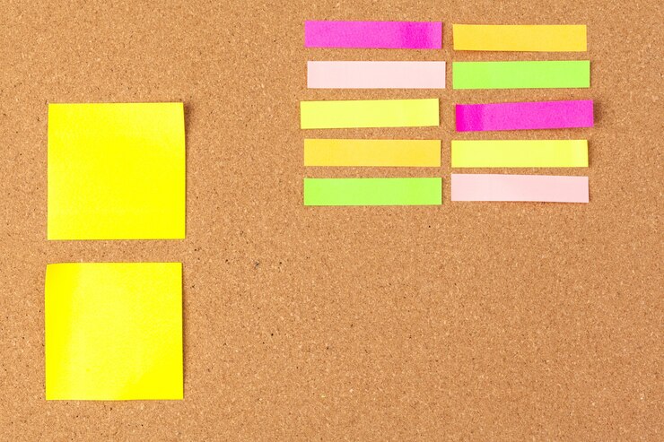 Foto tablero de corcho con varias notas en blanco coloridas con alfileres