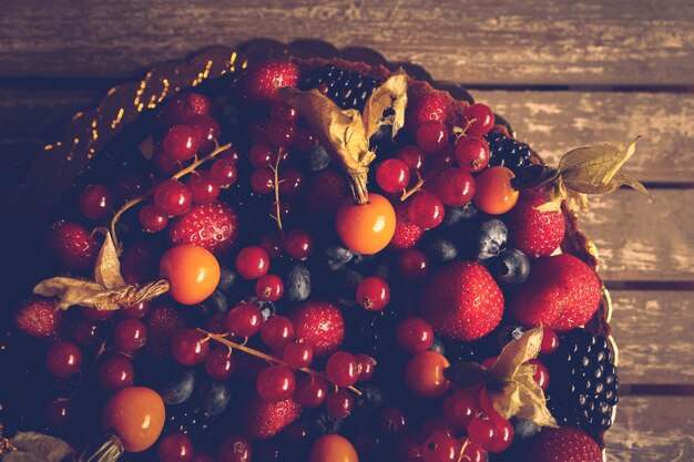 Tablero con delicioso pastel con bayas y deliciosas frutas en la mesa