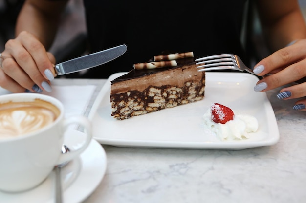 Tablero con delicioso pastel en la mesa