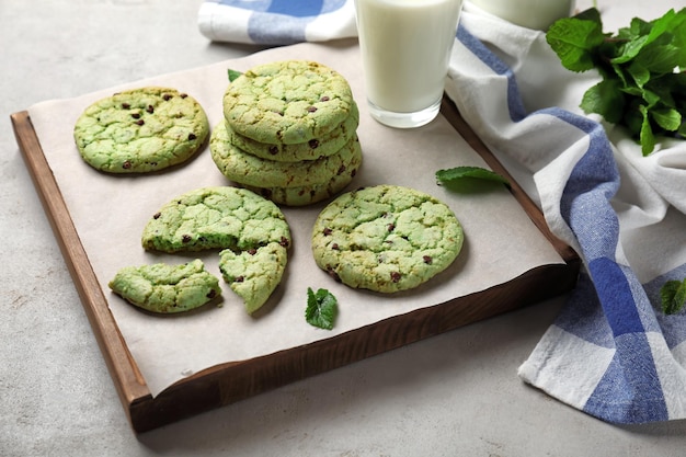 Tablero con galletas de menta con chispas de chocolate en la mesa