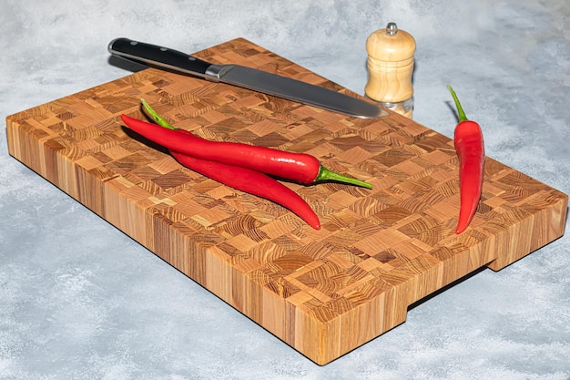 Tablero de madera para cortar productos hechos a mano con verduras picadas sobre un fondo claro