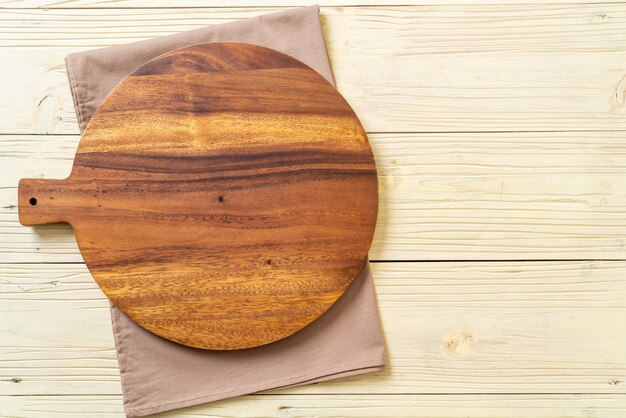 Foto tablero de madera de corte vacío con paño de cocina