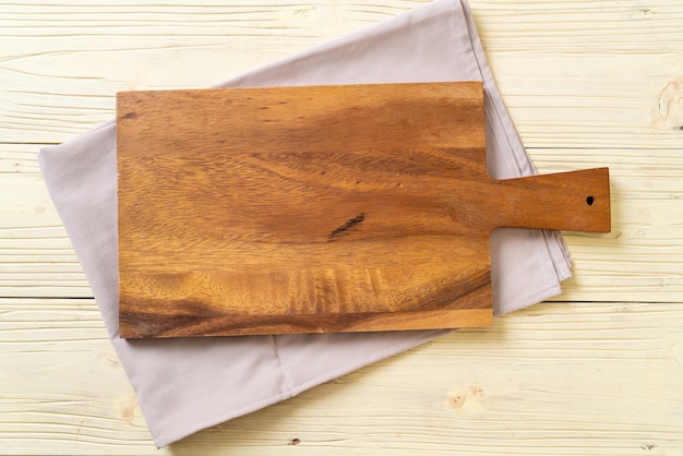 Foto tablero de madera de corte vacío con paño de cocina