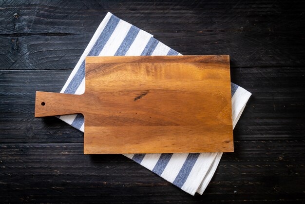 Foto tablero de madera de corte vacío con paño de cocina