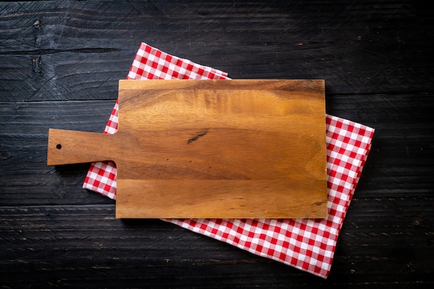 Foto tablero de madera de corte vacío con paño de cocina