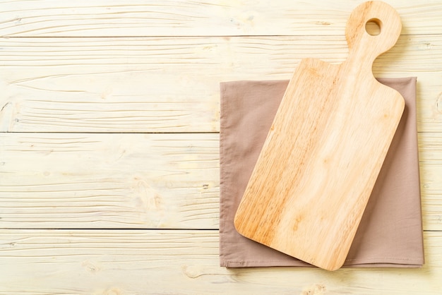 Foto tablero de madera de corte vacío con paño de cocina