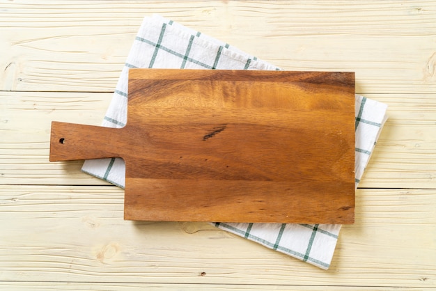 Foto tablero de madera de corte vacío con paño de cocina