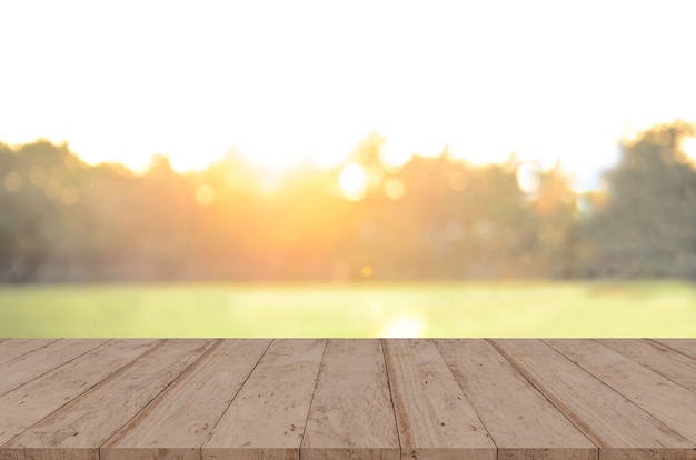 Tablero de madera frente a árboles en el bosque. imagen de fondo borroso al atardecer, para montaje de exhibición de productos.