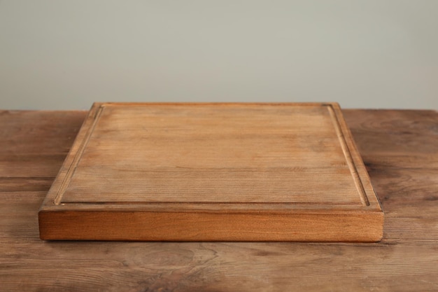 Tablero de madera en la mesa contra un fondo gris