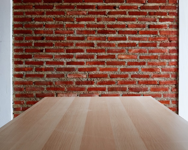 Tablero de madera mesa vacía con un fondo de pared de ladrillos rojos