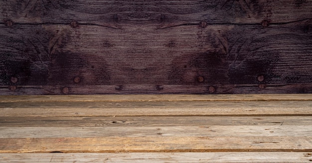 Foto tablero de madera mesa vacía frente al fondo de la pared oscura