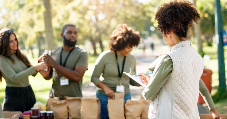 Foto tablero de mujeres y grupo de voluntariado o ayuda a ong de bondad y proyecto de caridad con la comunidad en el parque distribución de paquetes de alimentos y cajas de comestibles para donaciones trabajo en equipo y cuidado con lista de comprobación